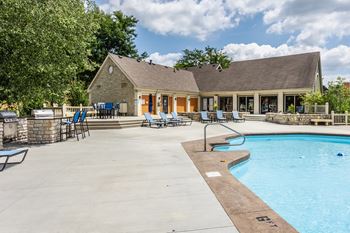 A pool and a house with a patio.